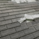 An image showing a damaged roof with missing shingles