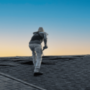 A professional roofing contractor inspecting a roof for damage.