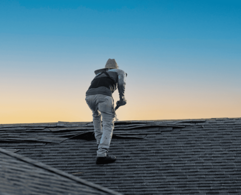 A professional roofing contractor inspecting a roof for damage.