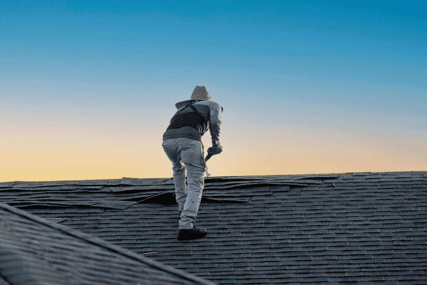 A professional roofing contractor inspecting a roof for damage. A professional roofing contractor inspecting a roof for damage.